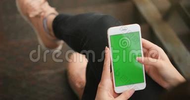 女孩使用手机绿色屏幕户外城市环境红色电影院4K手握商务智能手机